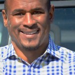 guns: Smiling man in blue checked shirt.
